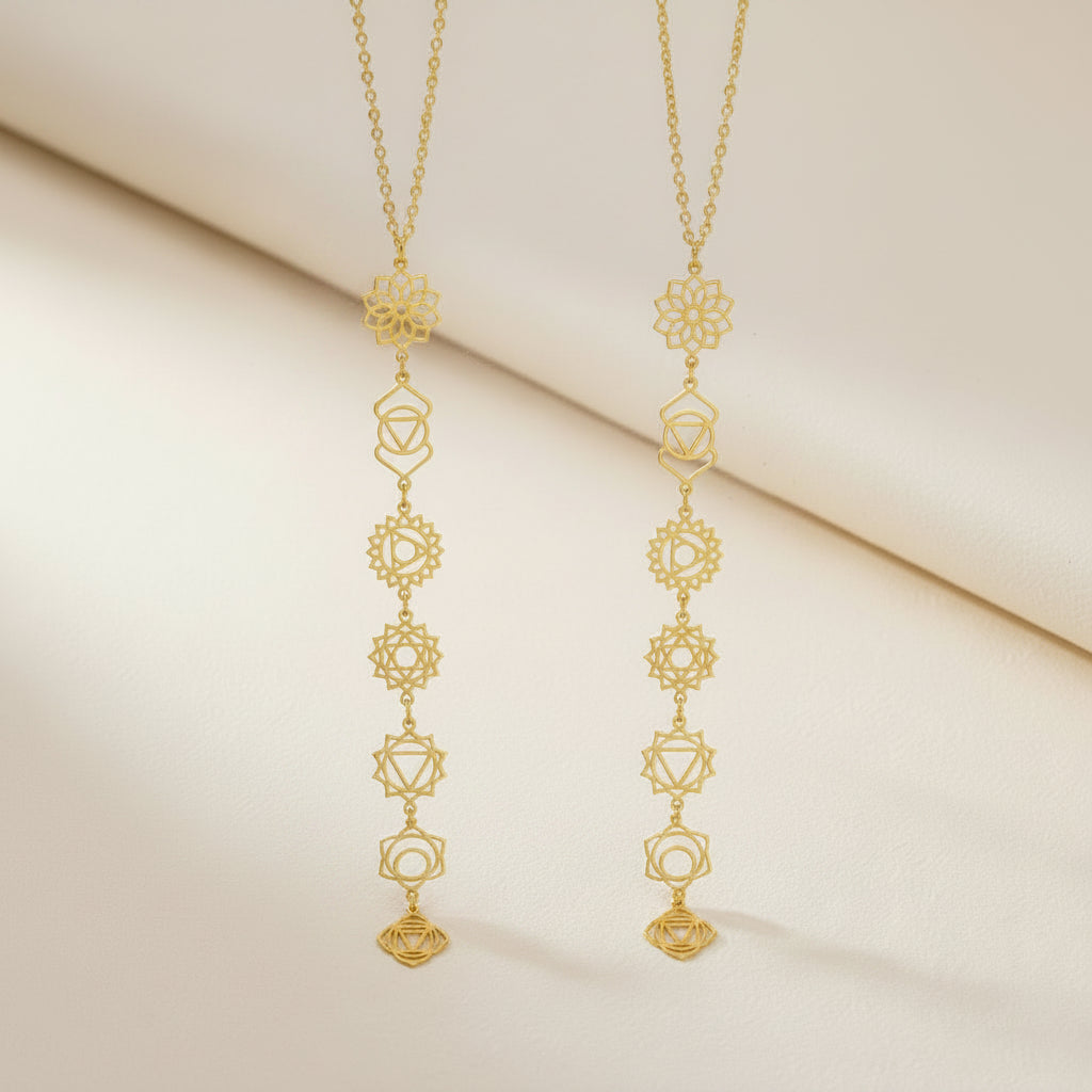 Elegant woman wearing a long gold chakra necklace with delicate spiritual symbols in a minimal style.